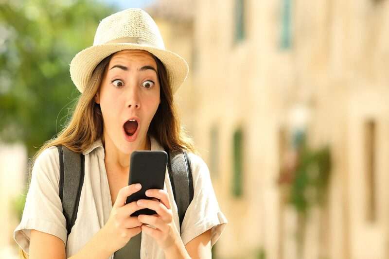 女性がスマホを見ていて、びっくりしている様子