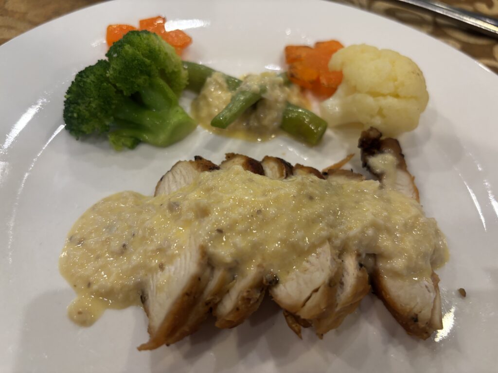 ホイアンのレストランGODAで提供された鶏むね肉のオーブン焼きと添え野菜
