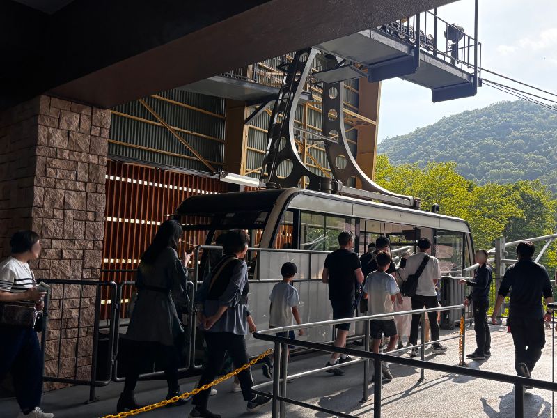 有珠山ロープウェイの山麓駅でゴンドラに乗り込む観光客の様子