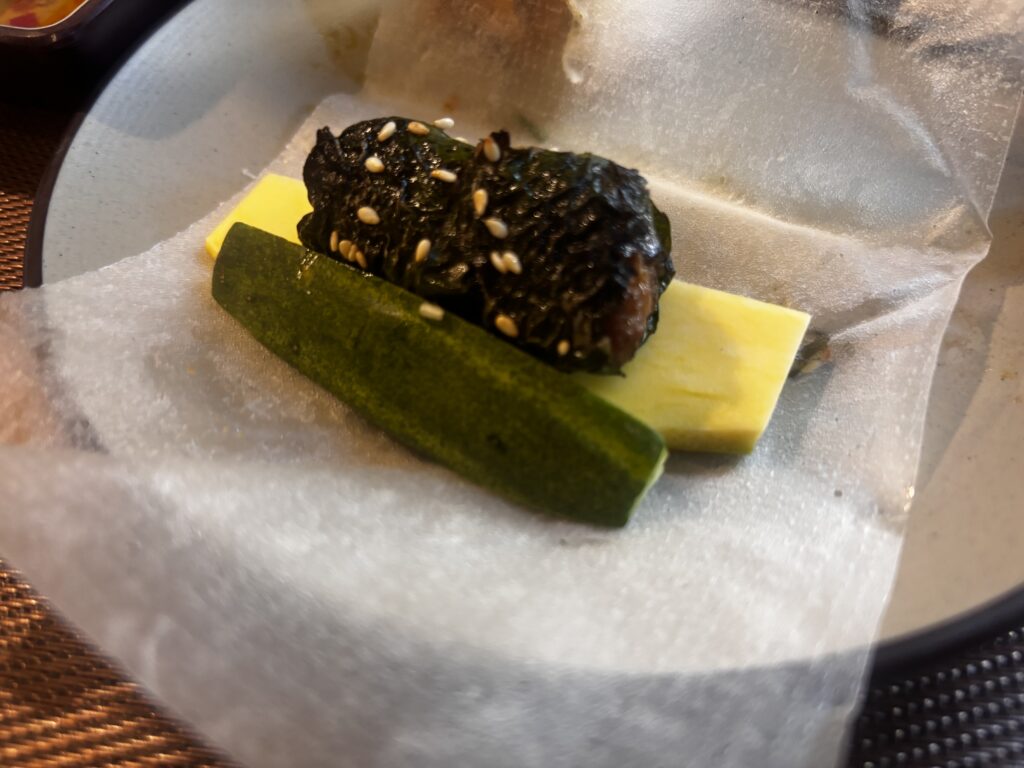 ダナンのNgon Thi Hoa Restaurantでボー・ラーロットをライスペーパーで巻く様子