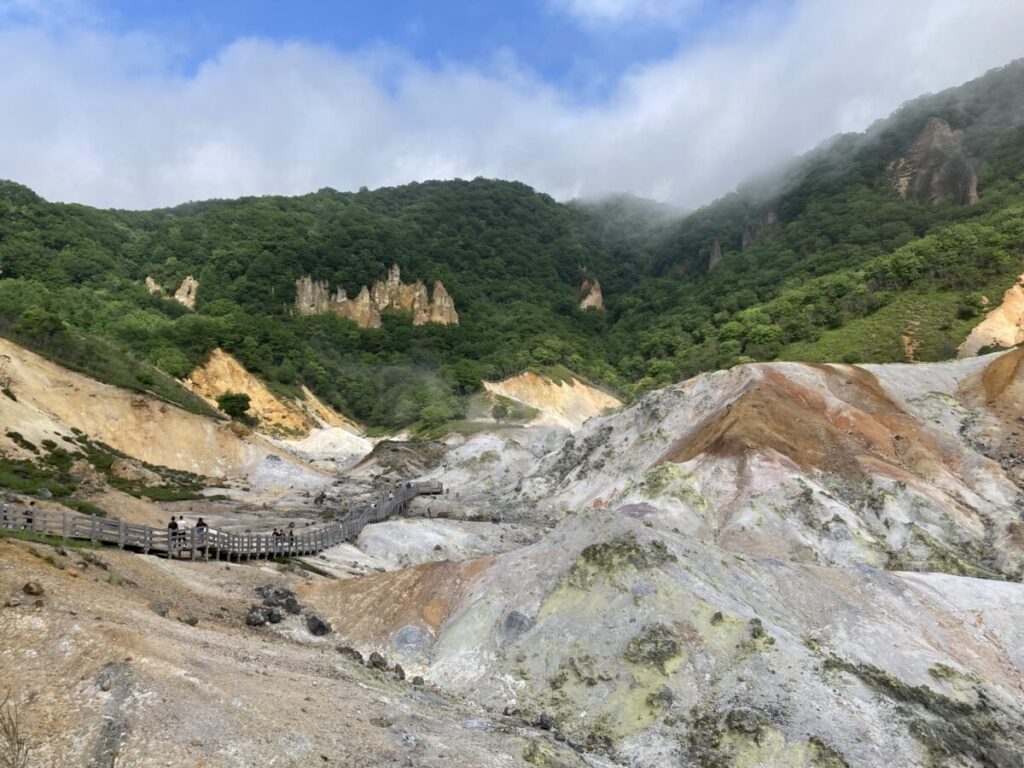 登別地獄谷の鉄泉池へ続く木道の遊歩道と、白く染まった谷の全景