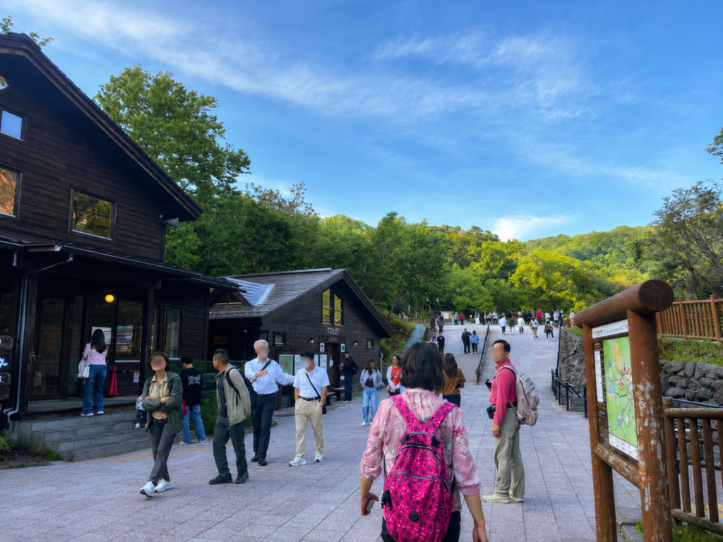 登別地獄谷の入口に立つ看板と、その先に広がる噴気の谷
