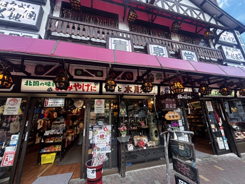 登別温泉街のお土産店「貴泉堂」の店先に並ぶ木彫りや北海道の菓子