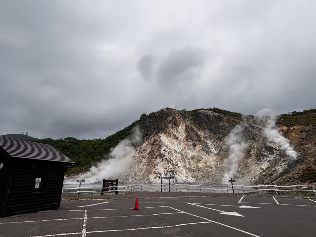 大湯沼駐車場から望む湯けむりの噴気地帯と広い駐車スペース