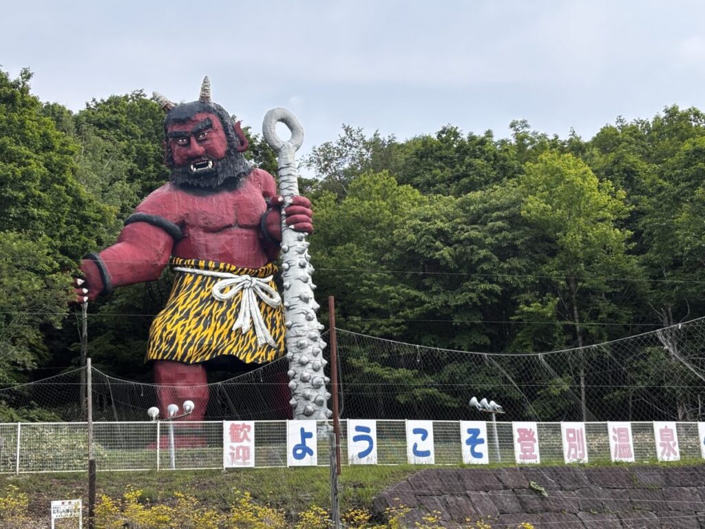 「ようこそ登別温泉へ」と書かれた歓迎看板と、巨大な赤鬼の像