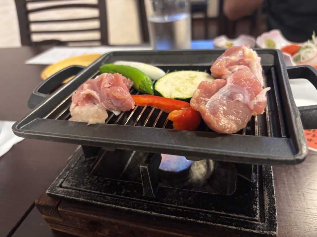 伊達産めぐみの陶板焼き、鉄板にのった鶏肉とズッキーニや赤ピーマン