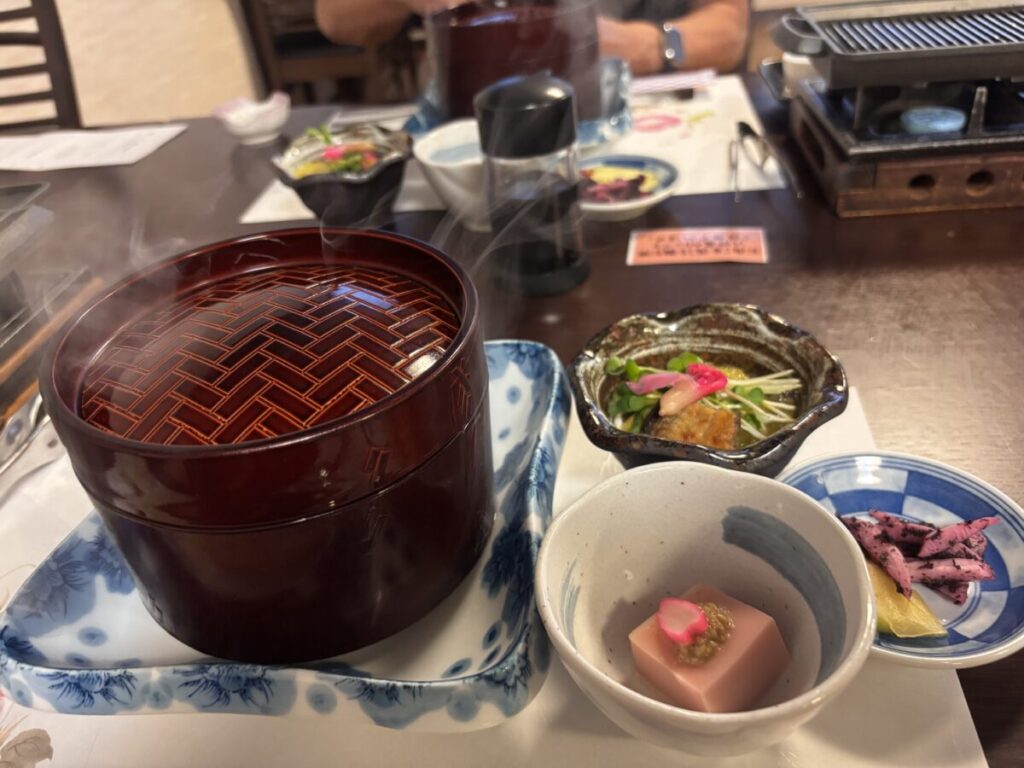 ゆとりろ洞爺湖の会席料理の最初の膳、桜胡麻豆腐の先附や小鉢と蓋付きの器